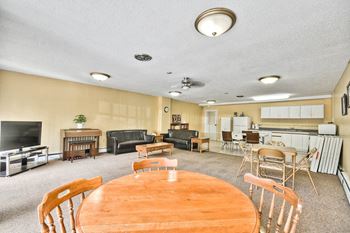 Brockville Apartments in Brockville, ON social room with kitchenette and large screen TV